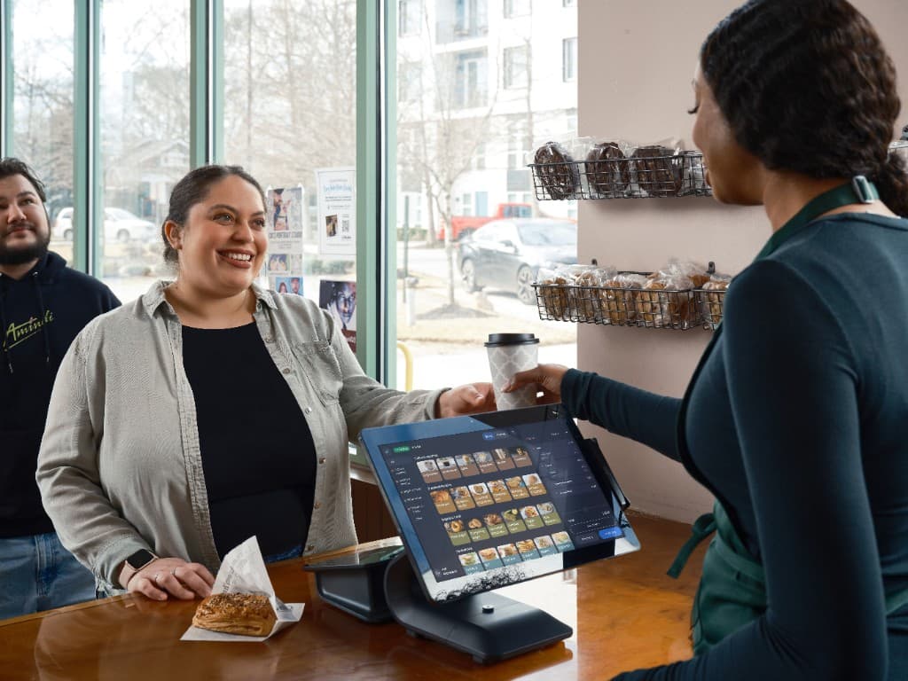 Touchscreenkassa aan de toonbank in een bakkerij, medewerker bedient klant